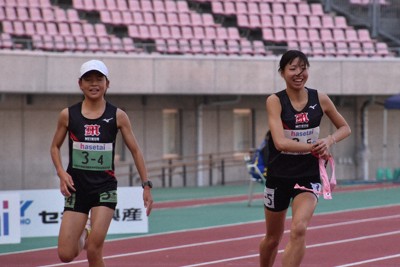 新潟明訓4区日下部結唯（左）からたすきを受け取り笑顔で走り出す5区福田せりえ＝新潟市中央区で2025年10月30日午前11時24分、戸田紗友莉撮影