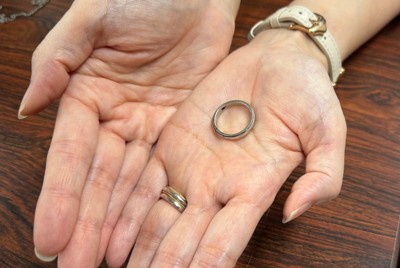 杉平裕紀さんの結婚指輪を手にする智里さん。指輪をネックレスにして裁判に臨んだ＝東京・霞が関の司法記者クラブで、2025年9月17日午後6時半、安達恒太郎撮影