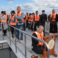 現場海域でじっと手を合わせて冥福を祈る遺族ら＝愛媛県今治市の伯方島沖で2025年11月3日午後0時2分、松倉展人撮影