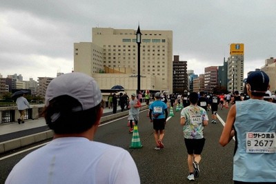 新潟市街地の象徴である国重要文化財「万代橋」のど真ん中を走るランナー＝新潟市中央区で2025年10月12日、木下訓明撮影