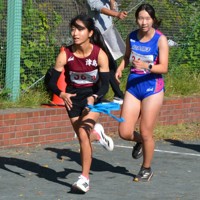 愛知県予選でタスキをつなぐ合同チームの知多翔洋・岩瀬奈都美（右）と津島・渡辺希依＝一宮市で2025年11月3日午後1時42分、川瀬慎一朗撮影