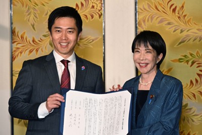 署名をした連立政権合意書を手に写真に納まる自民党の高市早苗総裁（右）と日本維新の会の吉村洋文代表＝国会内で2025年10月20日午後6時16分、平田明浩撮影