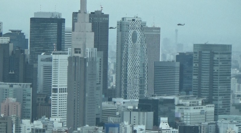 東京・新宿の高層ビル群近くを低空で通過する2機のブラックホーク＝都内で2020年7月9日、大場弘行撮影（写真は動画から）
