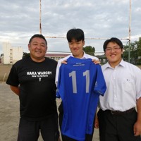 大会で着たジャージーを手にする青森県立八戸工高ラグビー部の八木橋証世さん（中央）。左は奈良慶一監督、右は荒谷翼さん＝同校グラウンドで2025年9月24日午後4時48分、早川健人撮影
