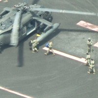 東京・六本木の米軍施設「赤坂プレスセンター」で米陸軍ヘリ「ブラックホーク」に乗り込む迷彩服姿の男女＝都内で2020年8月、大場弘行撮影（写真は動画から）