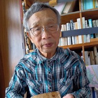 父の別所二郎蔵さんが樺太の収容所で書いた日誌を掲げる三男の三夫さん＝根室市で2025年8月28日午後2時53分、本間浩昭撮影