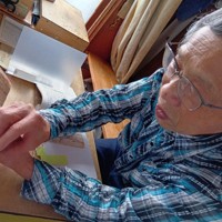 父の別所二郎蔵さんが書いた日誌をめくる三男の三夫さん＝根室市で2025年8月28日午後1時14分、本間浩昭撮影