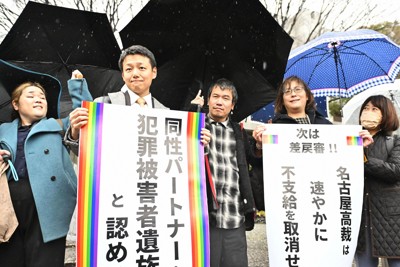 同性カップルが犯罪被害者給付金を受給できるかが争われた上告審判決を受け、紙を掲げる原告や原告側弁護団＝東京都千代田区で2024年3月26日、前田梨里子撮影