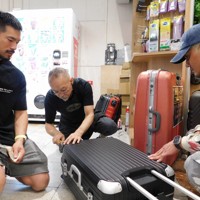 スーツケース修理の依頼に応じる中村一登さん（中央）＝千葉県成田市の成田空港で2025年10月7日午後4時半ごろ、合田月美撮影