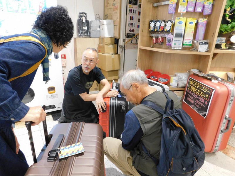 旅行者たちのスーツケース修理の依頼に応じる中村一登さん（中央）＝千葉県成田市の成田空港で2025年10月7日午後4時30分、合田月美撮影