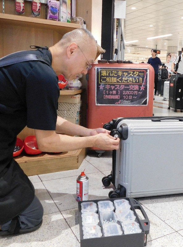 スーツケースを修理する中村一登さん＝千葉県成田市の成田空港で2025年10月7日午後4時4分、合田月美撮影