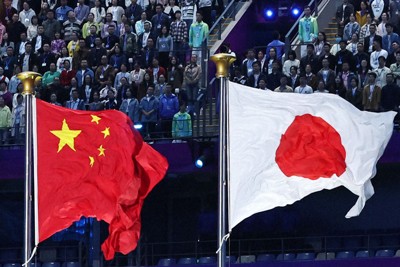 中国・杭州で開催されたアジア大会の閉会式で掲げられた日本と中国の国旗＝2023年10月8日、玉城達郎撮影