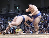 Yokozuna Onosato, right, beats Tamawashi during the eighth day of the Kyushu Grand Sumo Tournament at Fukuoka Kokusai Center in Fukuoka, on Nov. 16, 2025. (Kyodo)