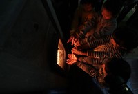 This photo shows children warming themselves by a stove in Kobe's Nada Ward on Oct. 24, 2019. (Mainichi/Yohei Koide)