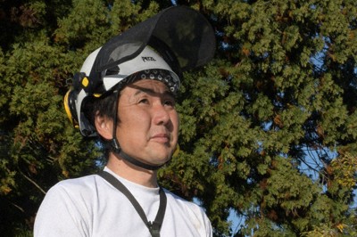 作業開始を前に木を見上げる阿部さん＝新潟県南魚沼市で2025年11月12日、板鼻幸雄撮影