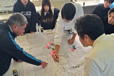 地区の地図を指さしながら、真剣に語り合う住民と富山大の学生ら＝石川県輪島市門前町七浦で、東栄一撮影
