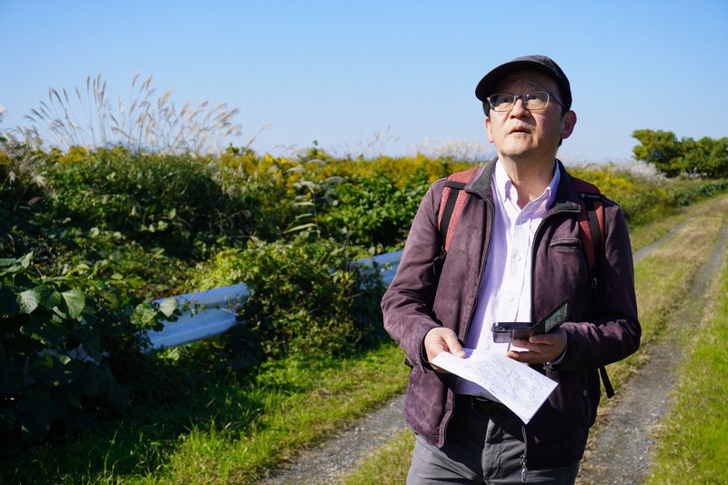 地図とスマートフォンを手がかりに廃線跡を探す今尾恵介さん＝茨城県内で2025年11月12日午前11時59分、後藤豪撮影