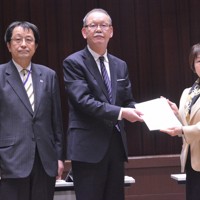 Toshiko Abe, minister of Education, Culture, Sports, Science and Technology, right, receives a report from Katsumi Arase, president of the Central Council for Education, in Tokyo's Chiyoda Ward on Feb. 21, 2025. (Mainichi/Kanami Ikawa)