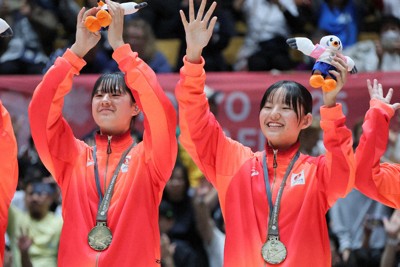 東京デフリンピック・バスケット女子決勝を制し、金メダルを受け取って観客に手を振る日本代表の（左から）加藤志野選手と加藤志希選手＝東京・大田区総合体育館で2025年11月25日、和田大典撮影