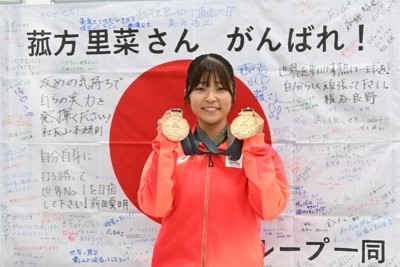獲得した二つのメダルを手にする菰方里菜選手。日の丸には、大会前に島津製作所の社員らからの応援メッセージが書き込まれた＝京都市中京区で2025年11月28日午後2時48分、日高沙妃撮影