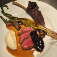 This photo shows various cuts of bear meat. Clockwise from top-right, belly meat on the bone used for the rue with French brown sugar, roast thigh meat with honeyberry sauce, and small cuts of bear heart. (Courtesy of Les KaneKiyos)