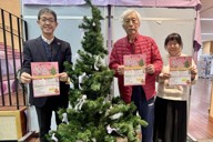 プレゼント事業を支える梅村孝雄さん（中央）を囲む倉林千恵子さん（右）と、内田圭三さん＝埼玉県本庄市内で2025年11月27日、隈元浩彦撮影