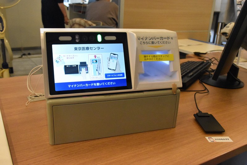 スマートフォンに搭載されたマイナ保険証に対応するための機器。右手前にあるのが、スマホに対応するカードリーダー＝東京都目黒区で2025年7月2日午後0時33分、寺原多恵子撮影