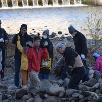 散乱した石を集めながら積み上げていく市民ら＝兵庫県宝塚市の武庫川中州で2025年12月6日午前9時51分、関谷徳撮影