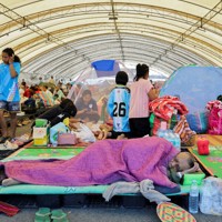 カンボジアとの武力衝突から逃れて避難所で過ごすタイ側の住民ら＝タイ東北部ブリラム県で2025年12月8日、ロイター