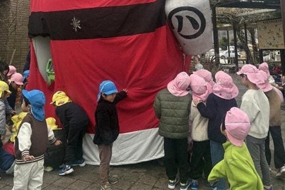 サンタクロースの姿に変身した巨大タヌキ像に集まる園児＝甲賀市信楽町長野で、2025年12月8日午前10時48分、、菊池真由撮影