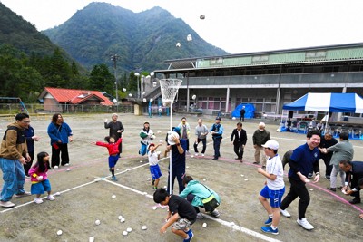 「わらべどんぐり祭り」で行われた玉入れ。児童だけでなく、保護者や地域住民、警察官や町長まで参加し、年齢の枠を超えて歓声が広がった＝山梨県早川町の町立早川北小で2025年10月11日、渡部直樹撮影