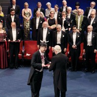ノーベル賞授賞式で、スウェーデンのカール16世グスタフ国王（手前右）から生理学・医学賞のメダルと賞状を授与される坂口志文・大阪大特任教授（同左）＝10日、ストックホルムのコンサートホール（代表撮影・共同）
