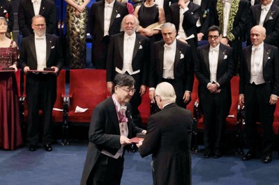 ノーベル賞授賞式で、スウェーデンのカール16世グスタフ国王（手前右）から生理学・医学賞のメダルと賞状を授与される坂口志文・大阪大特任教授（同左）＝10日、ストックホルムのコンサートホール（代表撮影・共同）