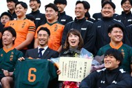 東福岡高校ラグビー部だった広木淳さんに授与された特別卒業証書を手に、記念写真に納まる母ますみさん（前列中央右）と当時の主将で早稲田佐賀高ラグビー部監督の山下昂大さん（同左）＝福岡市博多区で2025年12月11日、玉城達郎撮影