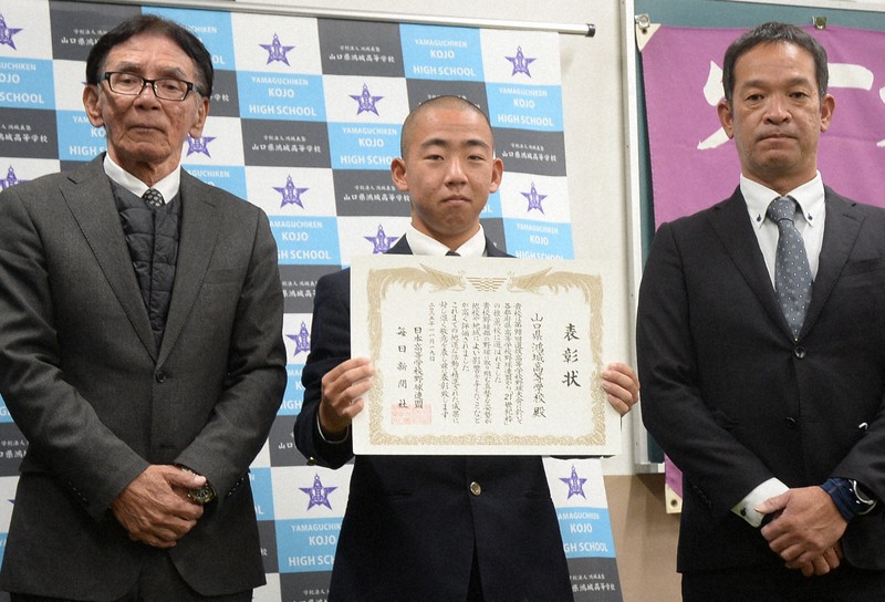 第98回選抜高校野球大会「21世紀枠」の山口県推薦校に選ばれ、表彰状を受け取った山口鴻城の藤本太陽主将（中央）と原田孝浩校長（左）、田村智監督＝山口市の同校で2025年11月19日、三森輝久撮影