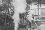 お寺の境内で落ち葉のたき火をする僧侶＝東京都葛飾区青戸の延命寺で1955年1月