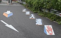 This photo, courtesy of the Central Nippon Expressway Co., shows markings on the surface of an expressway designed to look three dimensional to attract attention.