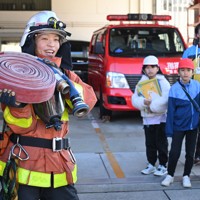 神戸市垂水消防署を見学に訪れた同市立舞多聞小学校の児童たちに活動の説明をする消防士の山本奈緒さん＝神戸市垂水区で2025年12月9日、大西岳彦撮影