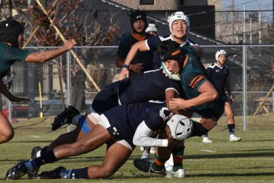 攻め込んできた東福岡の選手（右）に2人がかりでタックルする大分東明の選手＝大分市内で2025年12月7日午後2時58分、林大樹撮影