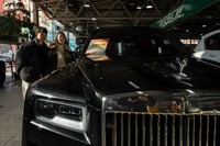 Visitors look at a second hand luxury car for sale in Beijing on Friday, Nov. 21, 2025. (AP Photo/Ng Han Guan)
