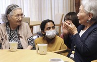Rincy George, center, who moved to Japan from India, works at a nursing home in Tokyo's Taito Ward in August 2025. (Kyodo)