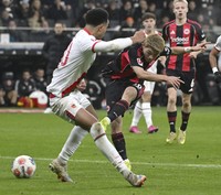 Eintracht Frankfurt's Ritsu Doan, right foreground, takes a shot during a German Bundesliga match against Augsburg at Deutsche Bank Park in Frankfurt on Dec. 13, 2025. (Kyodo)