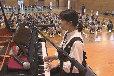 中学でピアノを演奏するYUNAさん