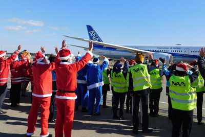 サンタクロースなどにふんして駐機場から旅客を見送るスタッフたち＝千葉県成田市で2025年12月12日午前11時8分、合田月美撮影