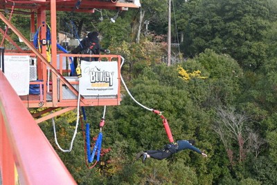 「開運橋」の特設ジャンプ台から意を決してジャンプする体験客＝三郷町の開運バンジーで、喜多瑞輝撮影