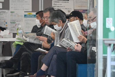 避難所のある佐賀関市民センターであった住民説明会で、大分市の配布資料を読む被災住民ら＝大分市佐賀関で2025年12月2日、山口泰輝撮影