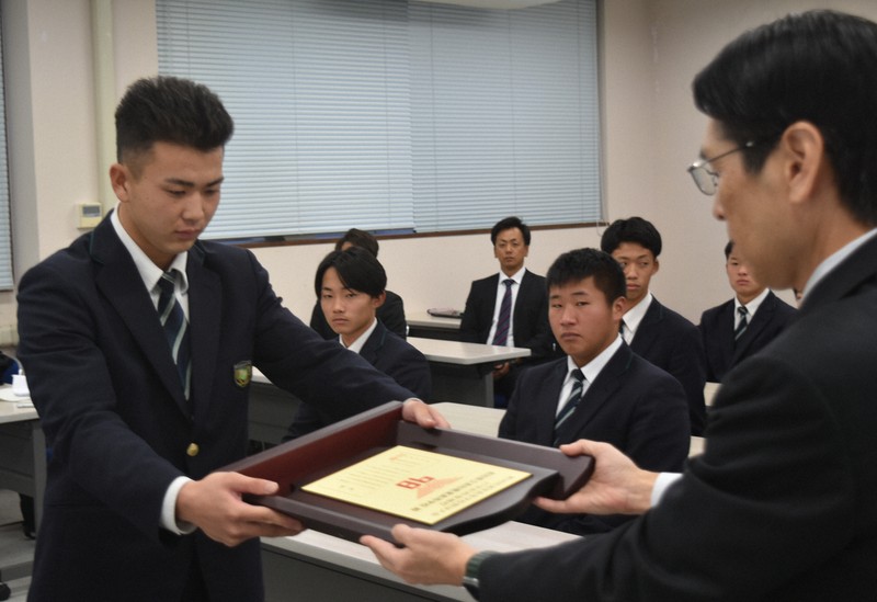 山岡晶・高知県高野連会長（右）からセンバツ21世紀枠の四国地区候補校の表彰盾を受け取る杉本仁主将＝高知県南国市の県立高知農業高校で2025年12月17日午後4時29分、行方一男撮影