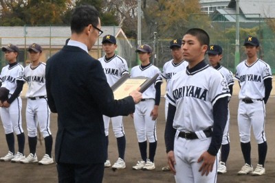 井上大作・毎日新聞奈良支局長（手前左）から表彰盾を受け取る田副皓大主将（2年）＝大和郡山市城内町の奈良県立郡山高校で、喜多瑞輝撮影