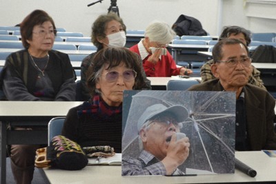 集会で上戸大典さんの遺影を掲げる原告たち＝長崎市で2025年12月17日午後1時58分、樋口岳大撮影