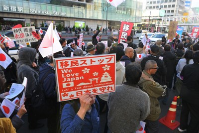 移民に反対するプラカードを掲げる人たち＝東京都新宿区で2025年11月30日午後2時45分